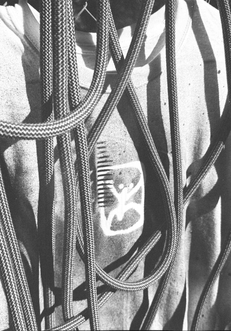 Coiled climbing ropes hanging over a shirt printed with the Dirtbag figure